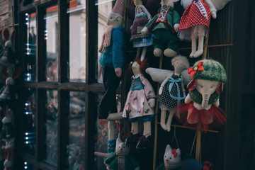 Soft toy of cotton in the store. Handmade doll with colorful woolen clothes in souvenirs shop. Colorful traditional toys selling in the market.