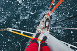 sailing boat in Antarctica, extreme dangerous  travel selfie, person feet standing on mast of a yacht with floating ice, top view, adventure