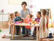 © New Africa - Young woman playing with little children indoors