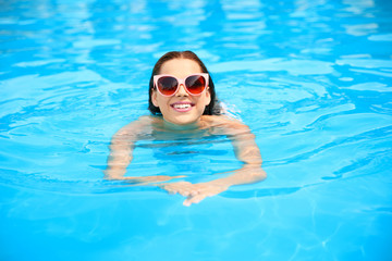 Poster - Beautiful young woman swimming in blue pool