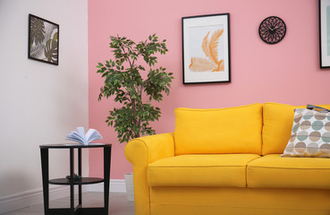 Poster - modern living room interior with comfortable yellow sofa near color wall