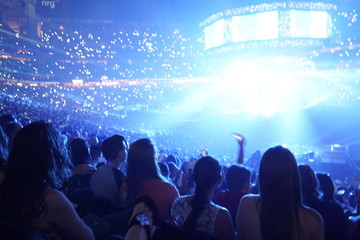 concert stage with shining lights and crowd at a performance. rock music event at a stadium with col