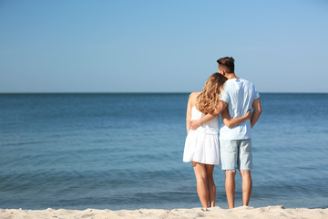 Poster - Happy young couple at beach on sunny day