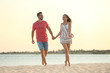 © New Africa - Happy young couple walking together on beach