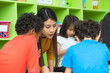 © weedezign - Asian female teacher teaching mixed race kids reading book in classroom,Kindergarten pre school concept.