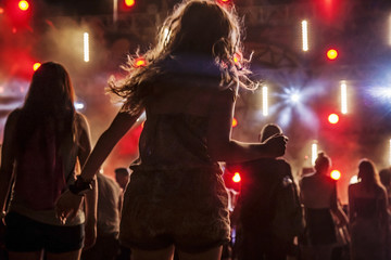 Dancing people at night concert party, blury background