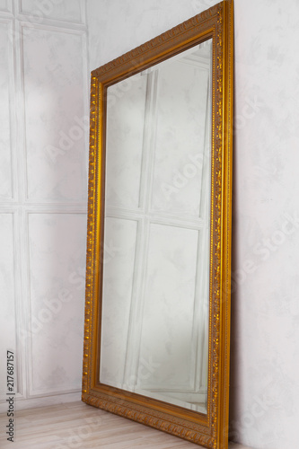 Fotografía Large classic mirror with golden wooden frame side view, home decor