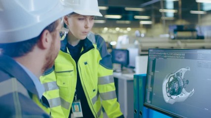 Poster - At the Factory: Male Mechanical Engineer and Female Chief Engineer Work Together on the Personal Computer, They Discuss Details of the 3D Engine Model Design.