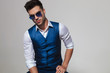 portrait of sexy man wearing a blue waistcoat and sunglasses