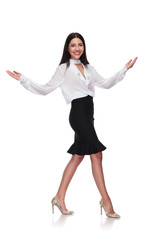 Wall Mural - smiling businesswoman walking to side and making a welcoming gesture