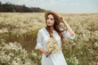 © LIGHTFIELD STUDIOS - portrait of pretty pensive woman in white dress with bouquet of wild camomile flowers on meadow