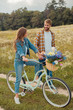 © LIGHTFIELD STUDIOS - smiling young lovers with retro bicycle in field with wild flowers