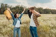 © LIGHTFIELD STUDIOS - cheerful couple with backpacks in summer field with wild flowers