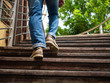 © Suriyawut - Adult man walking up the wooden stairs. Moving forward Concept.