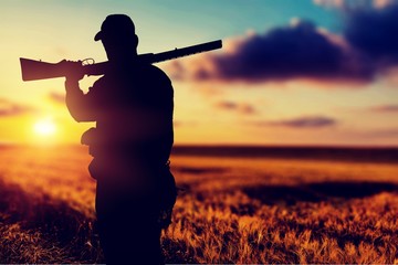 male hunter with rifle on natural background