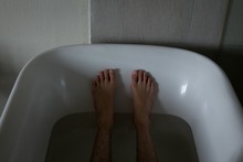 Low Section Of Man Relaxing In Bathtub