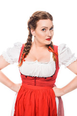 Wall Mural - beautiful oktoberfest waitress in traditional bavarian dress standing with hands on waist isolated on white background