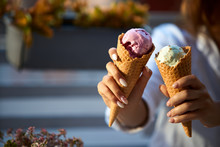 Close Isolated View Of Two Ice Cream Cones In Hand Of Women Friends Standing Outdoors. No Face, Copyspace For Designers. Buy One Get One Free, Two For The Price Of One, 2 For 1, Double Offer Concept.