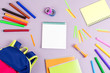 School concept flat lay. Kid backpack, notebook, markers on wooden desktop