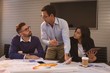 © Wavebreak Media - Business people discussing blueprint and graph chart