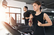 © sutthinon602 - Running on treadmills, Active young woman and man running on treadmill in gym