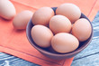 Eggs in a clay bowl on a wooden table