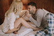 © BGStock72 - Young adult heterosexual couple on bed in bedroom