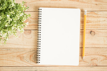Wall Mural - blank notebook and yellow pencil on brown wood,flat lay photo of notebook for your message