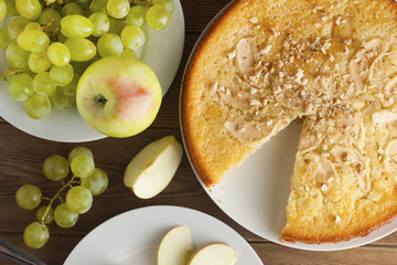 Wall Mural - Freshly baked apple pie rustic, dark wood background. Autumn fruits: grapes, apples, nuts. Still life dessert homemade food, top view.