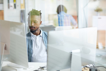 Wall Mural - Serious guy concentrating on studying or decoding new data while sitting in front of computer monitors