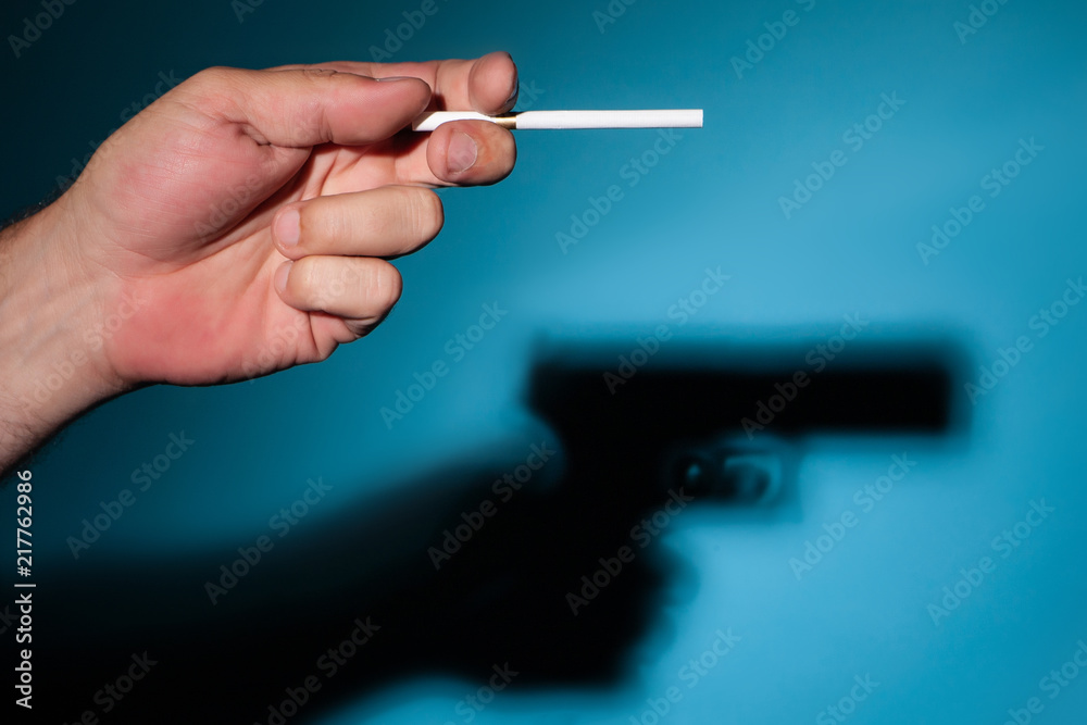 Cigarettes are being killed. Damage to health from smoking. Cigarette gun.  The shadow of a cigarette. Bad habit of smoking. Damage to health from smoking  cigarettes. Stock Photo