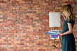 © golubovy - art painting leisure craft and hobby. drawing and creativity concept. girl painting a picture. blank paper ot easel. empty space for advertisement.