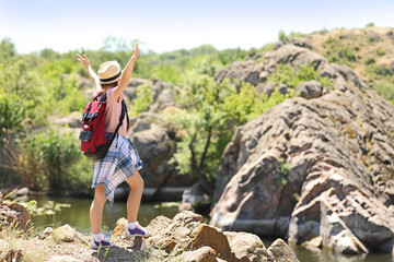 Wall Mural - little girl on rock near river. summer camp