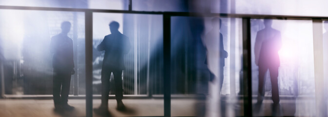 Wall Mural - Silhouettes of people walking in the street near skyscrapers and modern office buildings. Multiple exposure blurred image. Economy, finances, business concept illustration. Conseptual. 