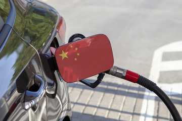 Fueling car with petrol pump at a gas station.