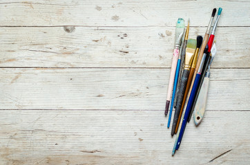 Sticker - Artist paint brushes on the wooden background