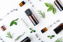 Essential Oils With Botles And Herbs On White Background