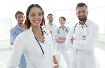 Attractive female doctor with medical stethoscope in front of medical group