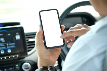 Cropped shot of businessman holding blank screen mobile phone in car.