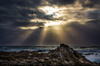 Sunrays break through the stormy clouds giving golden light with 4 birds silouhetted