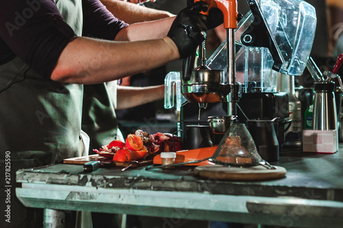 Fotografie, Obraz man's hand squeezes juice from citrus on a professional mechanical juicer