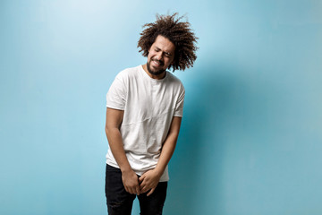 Wall Mural - A tanned man with flying curly hair is making dancing movements. The guy is smiling with his teeth. Hapiness and bliss.