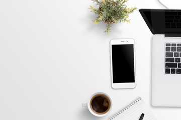 Wall Mural - Phone and laptop computer on white desk with free space for text. Plant, cup of coffee, notepad nad pencil beside. Flat lay composition.