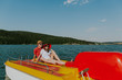 © Newman Studio - Cheerful man and woman having fun boating on the lake. Portrait of couple in love relaxing on pedal boat on warm sunny day.
