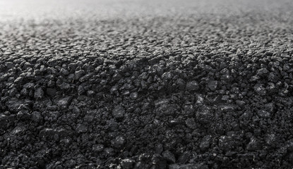 Close-up on a layer of new asphalt at the road under construction.