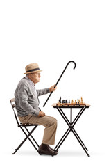 Poster - Senior seated at a table playing a game of chess and arguing