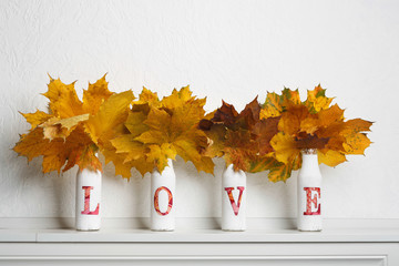 Wall Mural - Autumn maple leaves in bottles with word love