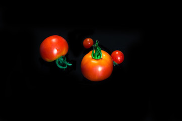 Cherry tomatoes closeup isolated on black background