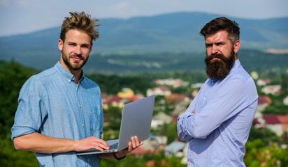 Wall Mural - Mobile internet concept. Colleagues with laptop work outdoor sunny day nature background. Business partners in formal wear with laptop or notebook taking advantages of mobile internet working outdoor