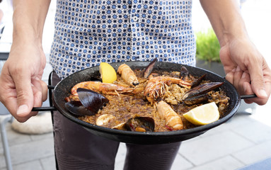 Canvas Print - man with a typical spanish seafood paella